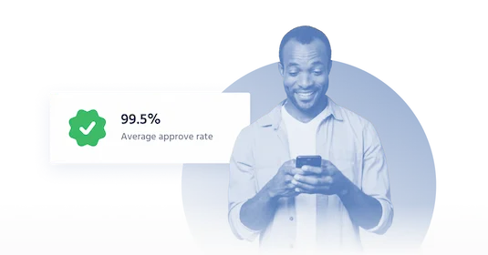 A man smiling while checking his phone with a badge indicating a 99.5% approval rate for a financial service