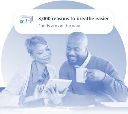 Couple smiling while reviewing $3,000 loan approval on tablet
