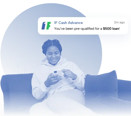 Woman sitting on a couch smiling at her phone after receiving a $500 loan pre-qualification notification from 1F Cash Advance