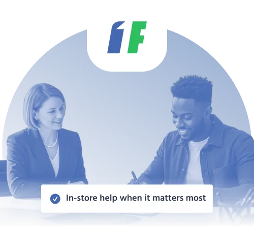 1F Cash Advance customer receiving in-store help from a smiling 1F cash Advance representative while signing loan documents